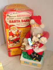 Santa Claus Bank Battery Operated Toy: Santa Claus mechanical Bank he raises arm rings bell, eyes flash and his head moves. Made by Noel Decorations Japan. Very good condition.