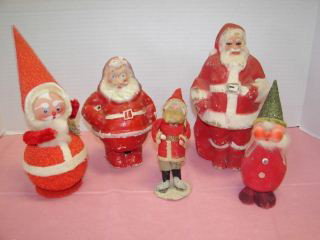 Group of 5 Santa Claus Figures: Round belly cardboard sanat candy container, 2 compo sanata (one has small between feet ) 1 Santa with a celluloid face, green hat figure missing arms.