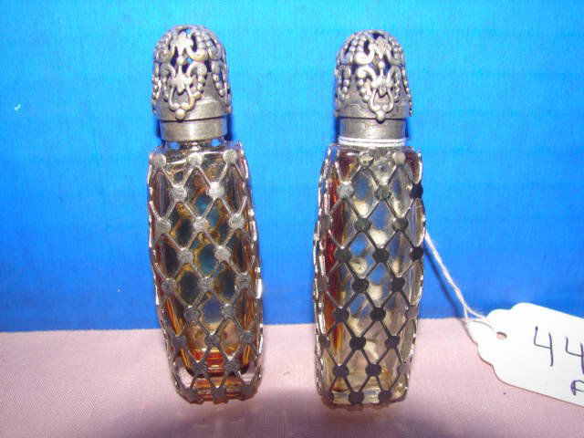 Pair of Mesh Covered Scent Bottles: Pair of 2 small scent bottles with ornate tops and metal overlay glass bottoms marked Made In France. Interior of bottles have residue amber color from perfume. 2 3/4" tall. Very good condition.