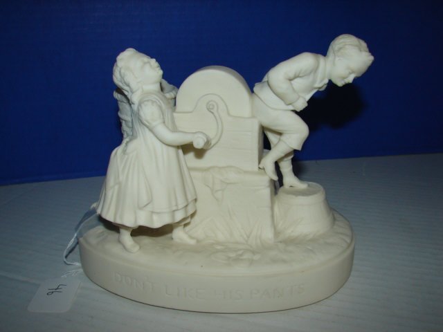 Parian Figure "Don't Like His Pants": Parian Figure of two children measures 7 1/2" x 8. Very good condition.