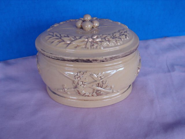yellow Ware Covered Box Civil War Motif: 4 1/2" x 3" covered oval box decorated with cannon balls on the top and crossed swords through a wreath on the bottom. Good condition.
