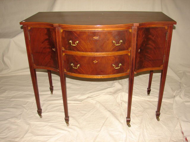 Mahogany Inlaid Server: Inlaid Mahogany bow front server measuring 40" wide and 23" deep. Brass castors on legs. Brass pulls. This server is part of a dining room set from the Keeler Mansion in Albany NY. Very good condition