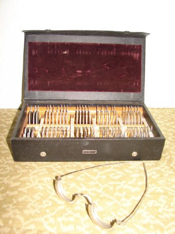 U.S. Navy Opitcal Instrument: Set of lenses and opticians glasses. The case is marked Medical Department U.S. Navy. The set of lenses and glasses are set in a wood lined snap box. Very good condition.