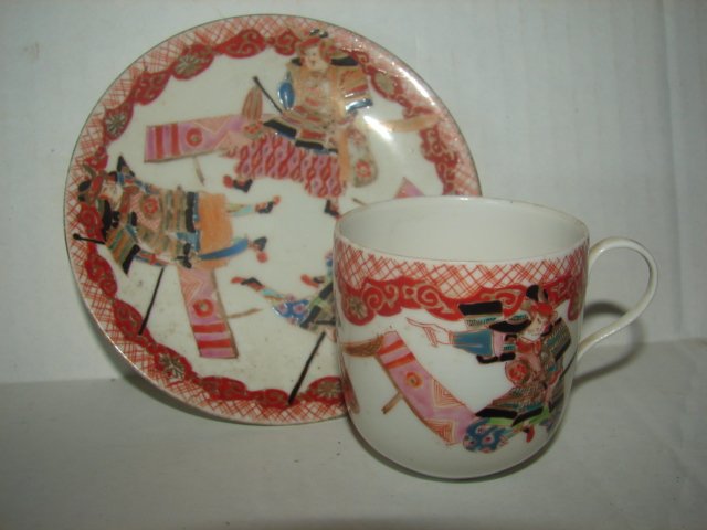 Asian Samuri Cup & Saucer: Tea cup and saucer measuring 2 1/2" tall by 4 1/2" diameter with Samuri warrior decoration. Bottom of cup and saucer signed. Very good condition.