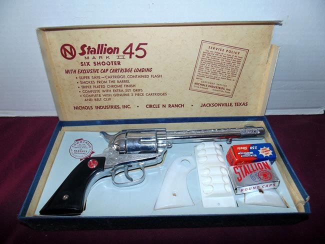 Nichols Stattion 45 Mark IICap Gun: Original box Nichols Stallion 45 Mark II Cap Gun with extra set of grips, smokes from barrel, chrome finish, 2 piece cartridges and belt clip. Very good condition.