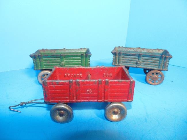 Cast Iron Arcade Wagons: 3 Cast iron wagons one marked Arcade. 3 1/2" and 4".