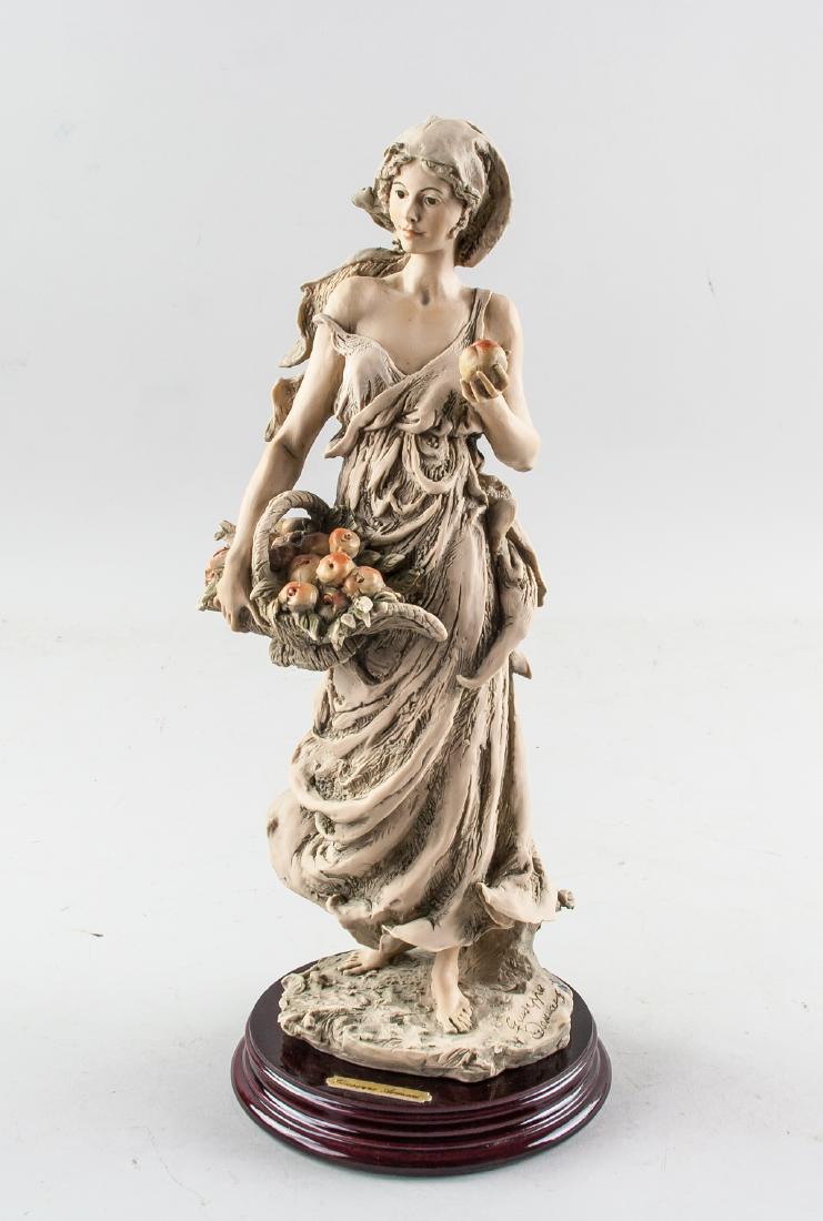 Giuseppe Armani Italian 1935 12' Woman & Bouquet: 12 inch figure, featuring a woman holding a basket of fruit Signed on base Giuseppe Armani (born 1935 Italian). Inscribed by artist on base. H: 30 cm, 845 grams. Giuseppe Armani was born in Calci, Ita