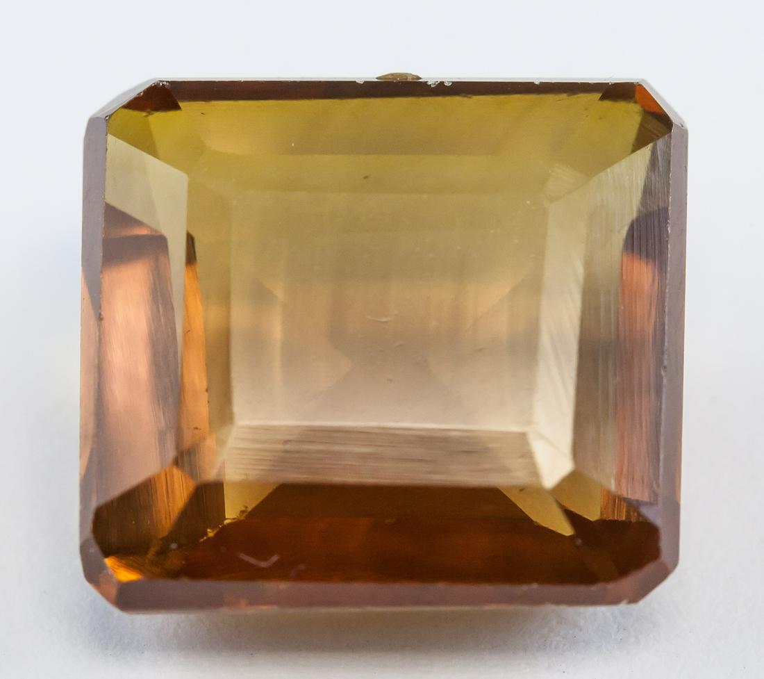 13.80ct Emerald Cut Golden Brown Sapphire GGL: One (1) 13.80 ct emerald cut golden brown sapphire gemstone. 13.21 x 12.10 x 6.74 mm. Accompanied with GGL certificate.
