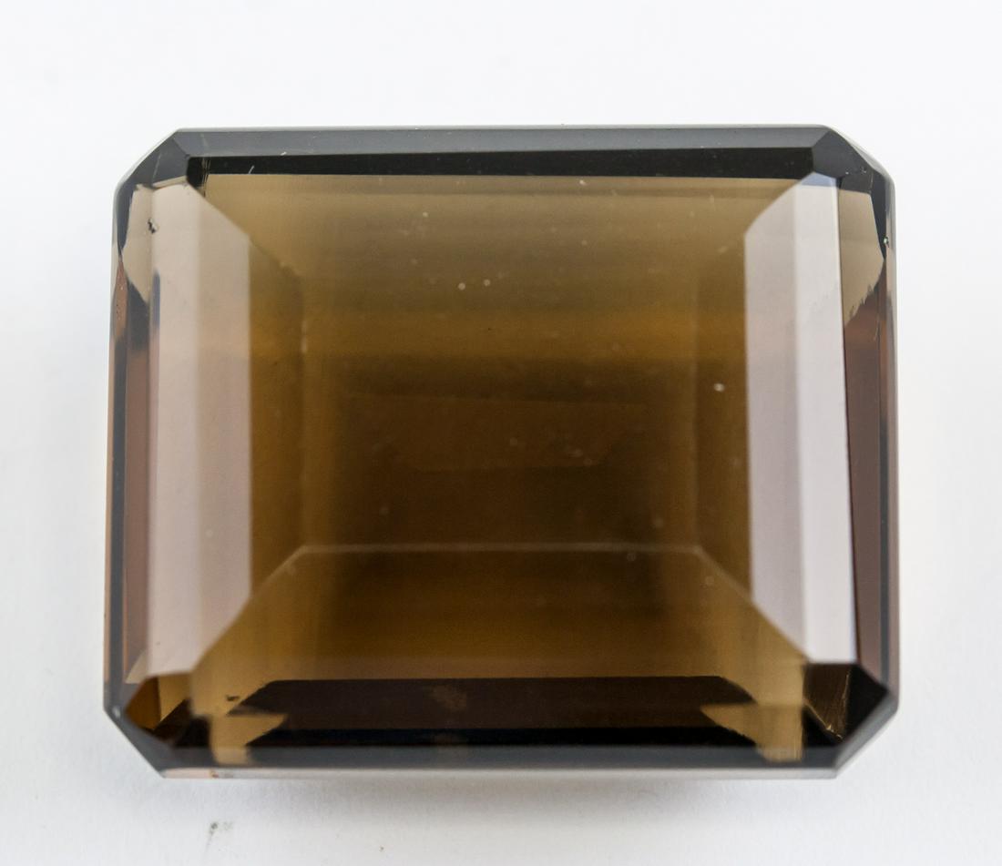 105.05ct Emerald Cut Natural Smoky Quartz AGSL: One (1) 105.05 ct emerald cut brown natural smoky quartz. 30.57 x 25.81 x 14.25 mm. Origin: Brazil. Accompanied with AGSL certificate.