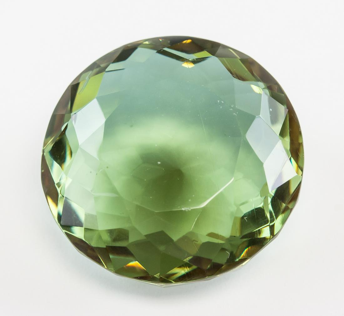95.00ct Round Cut Brown to Green Alexandrite GGL: One (1) 95.00 ct round cut brown to green Alexandrite. Origin: Brazil. Accompanied with a GGL certificate. 29.76 x 29.92 x 15.86 mm