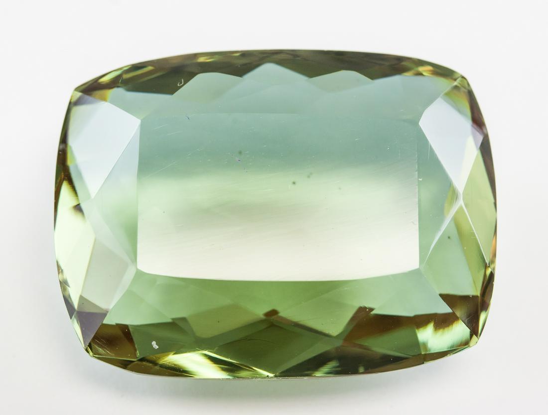 104.70ct Cushion Cut Green Natural Alexandrite GGL: One (1) 104.70 ct cushion cut brown to green natural alexandrite. Origin: Brazil. Accompanied with GGL certificate. 34.11 x 26.07 x 14.56 mm.