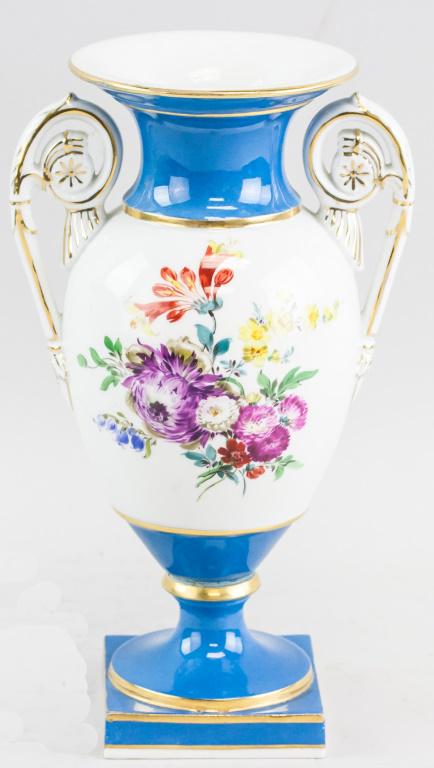 European Meissen Porcelain Vase Signed: European Meissen porcelain vase. With wide opening and large curved handles. With oval body and flared base resting on square pedestal. Of blue and white tone with colorful flowers. Blue mark on base.