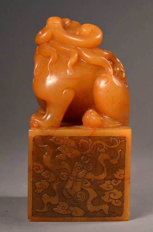 Large Carved Shoushan of Fu Lion and Cub: Large Chinese shoushan Tianhuang stone carving; of square form surmounted with an openwork fu lion and cub; low relief decorative carvings on square base; 6" tall, 3 1/4" wide, 3" long, wood stand