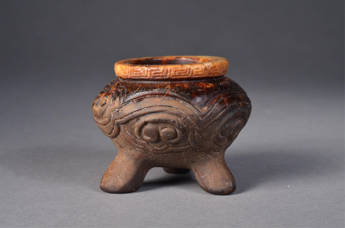 Chinese White Jade Taotie Tripod Censer: Chinese carved jade tripod censer; featuring taotie-like masks on squat ovoid body supported on tripod legs; key-fret border along the rim; brown suffusions throughout; D: 7 cm, H: 5.5 cm, 206 grams