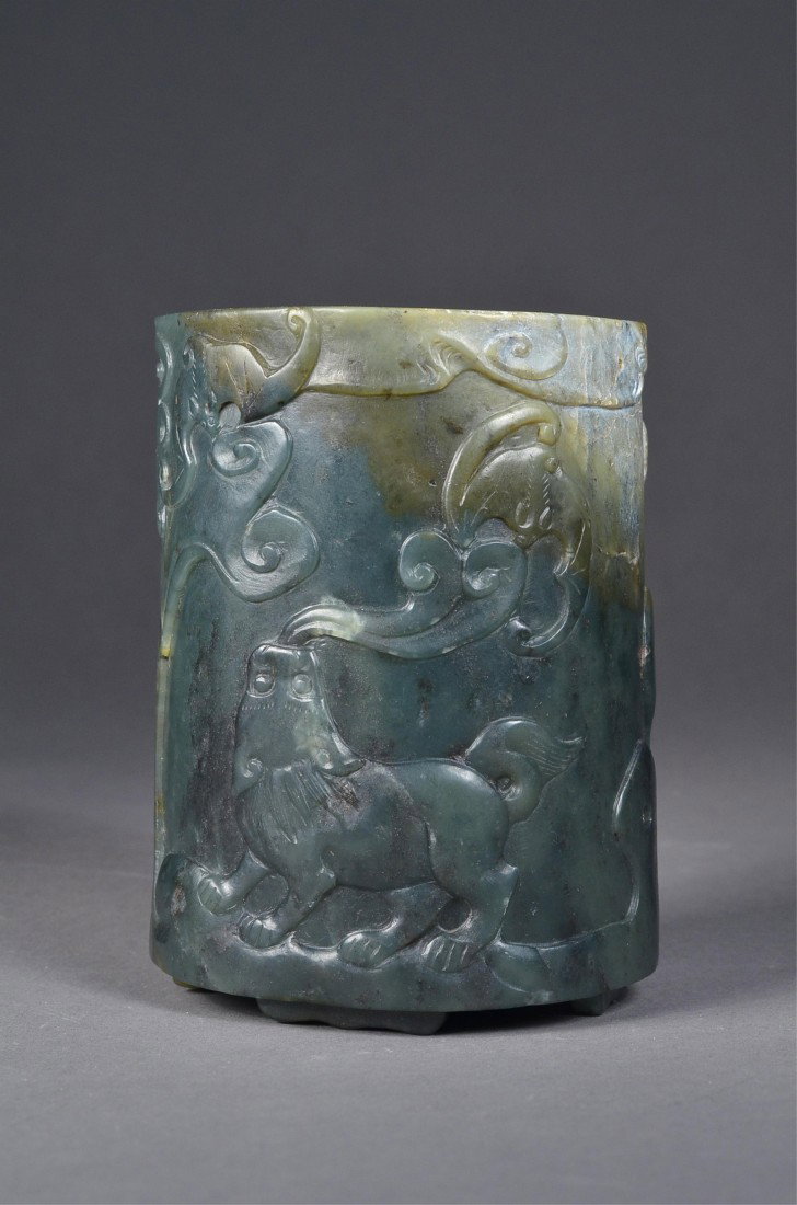 Chinese Spinach Green Jade Brush Pot Deer & Bat: Chinese carved jade brush pot; cylindrical body featuring deer, bat, and dragon in relief; spinach green colouration with light brown suffusions at rim; H: 11.5 cm, D: 8 cm, 657 grams