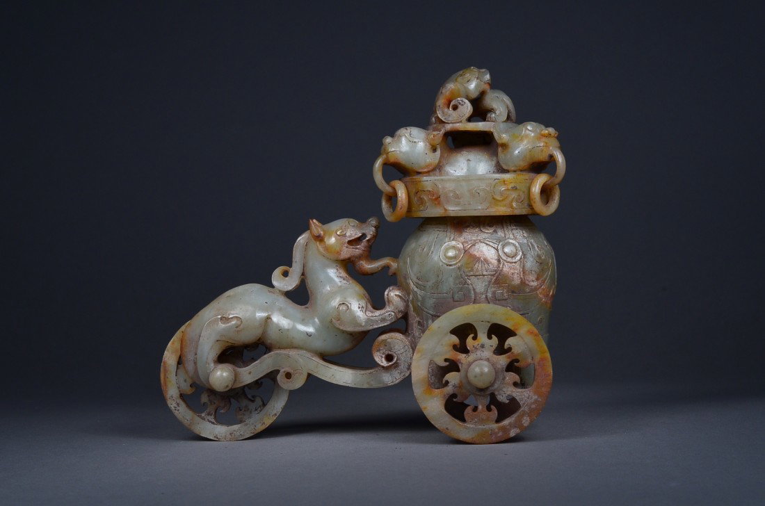 Archaistic Jade Carved Chariot Vessel: Archaistic carved jade chariot vessel; of circular form featuring cover with elaborate lions heads and open rings with lion finiale; the sides depicting lion or qilin with its front paws on the side o