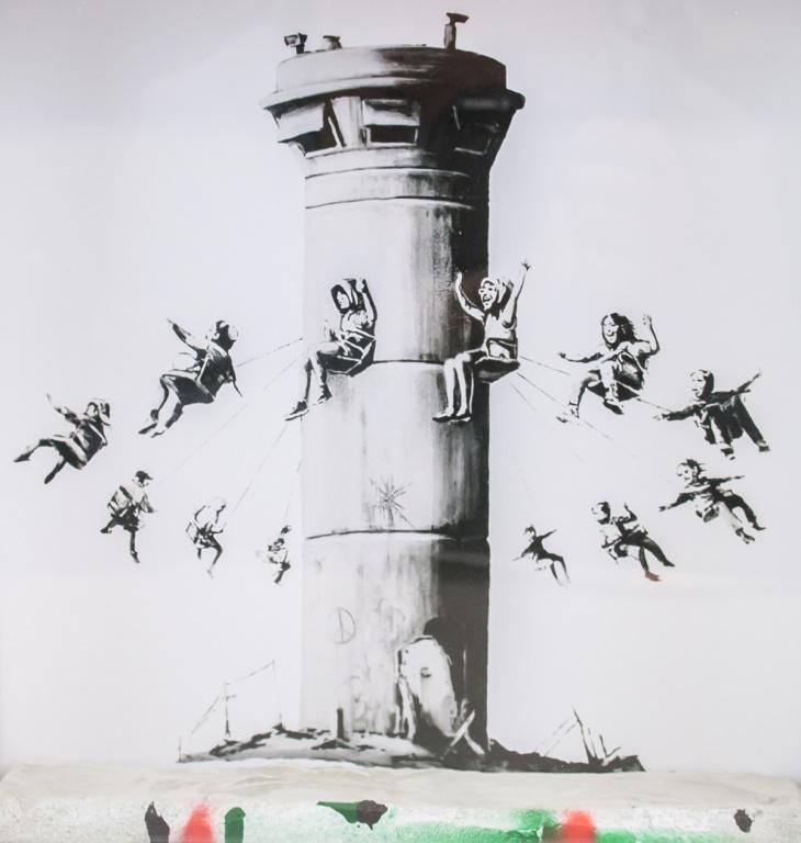 British Mixed Media The Walled Off Hotel by Banksy: Mixed media, 3D diorama, framed. Featuring a cement block with a background of children swinging around a tower like a amusement park ride. "3631" inscribed on verso. Accompanied with original purchas