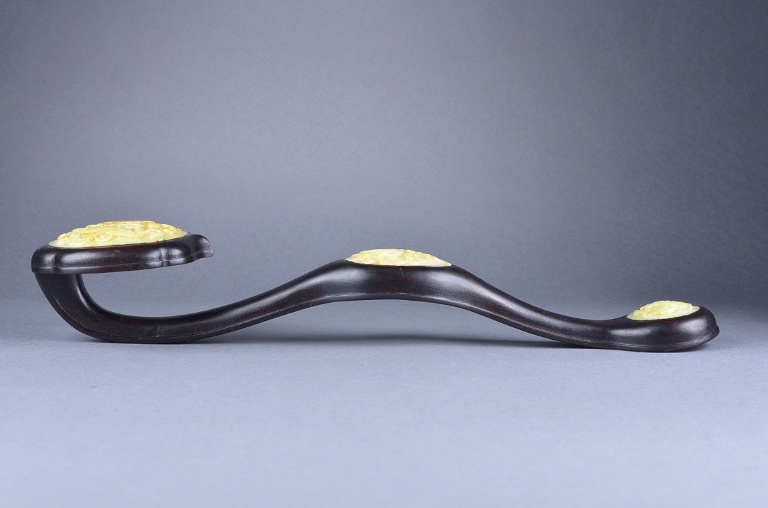 19th Century Chinese Zitan Ruyi Scepter Inset Jade: 19th Century Chinese carved zitan ruyi scepter featuring three inset white jade pieces; L: 43 cm, 529 grams
