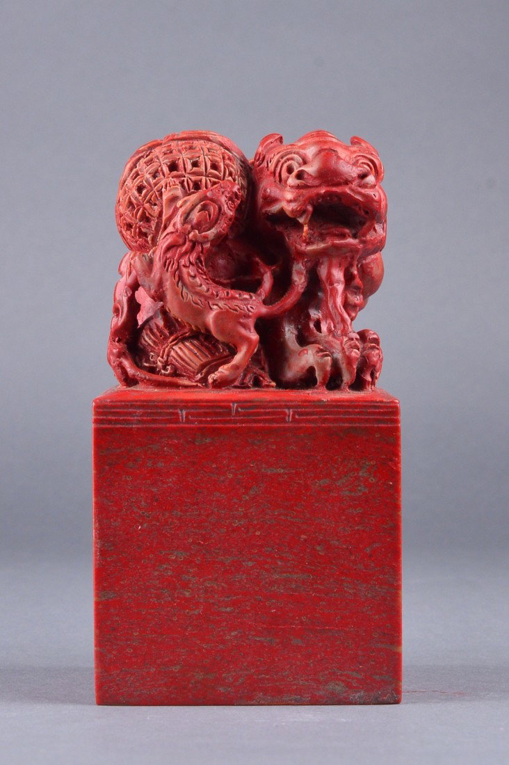 Chinese Bloodstone Carved Seal: Chinese carved bloodstone seal, surmounted by fu lion with puzzle ball in relief; four-character seal chop; H: 15 cm, L: 8 cm, W: 8 cm, 1698 grams