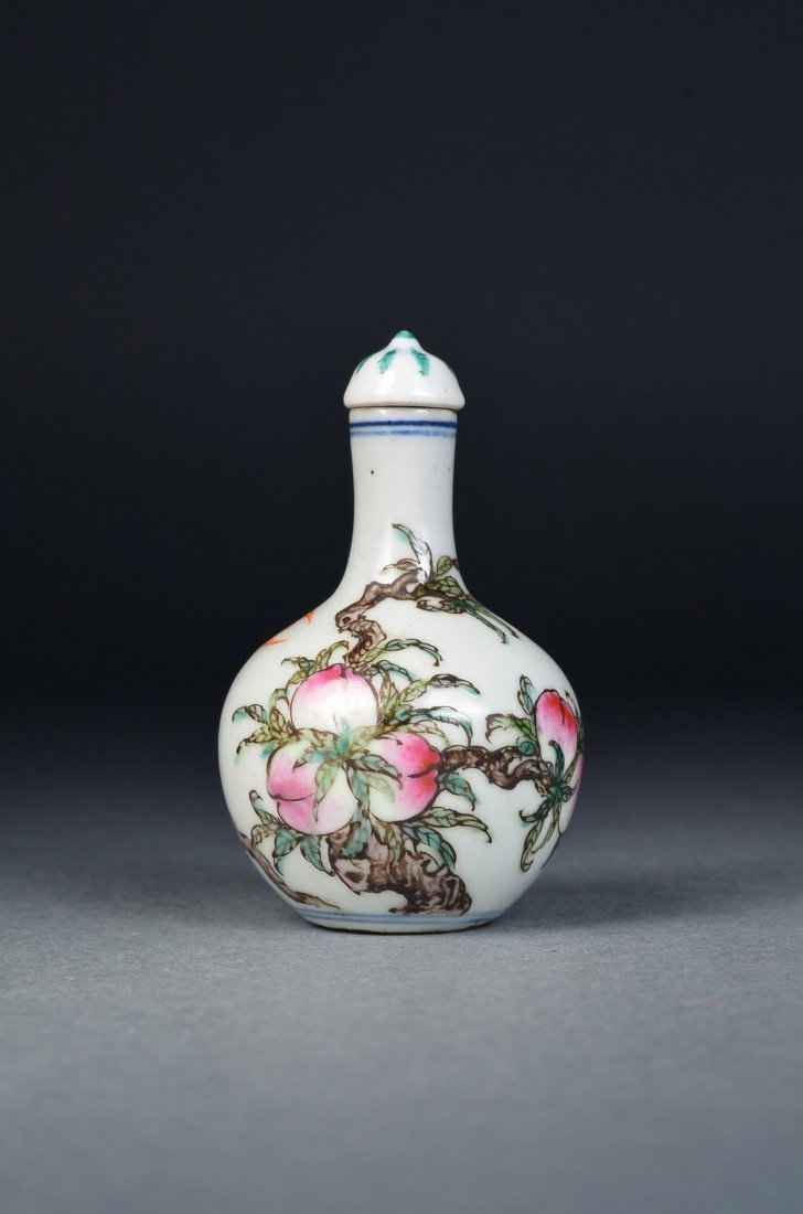 Chinese Porcelain Snuff Bottle Bats & Peaches: Chinese porcelain snuff bottle; globular body featuring peaches borne on branches with flying bats; the base decorated with encircling double circles, stopper; H: 7.5 cm, D: 5 cm