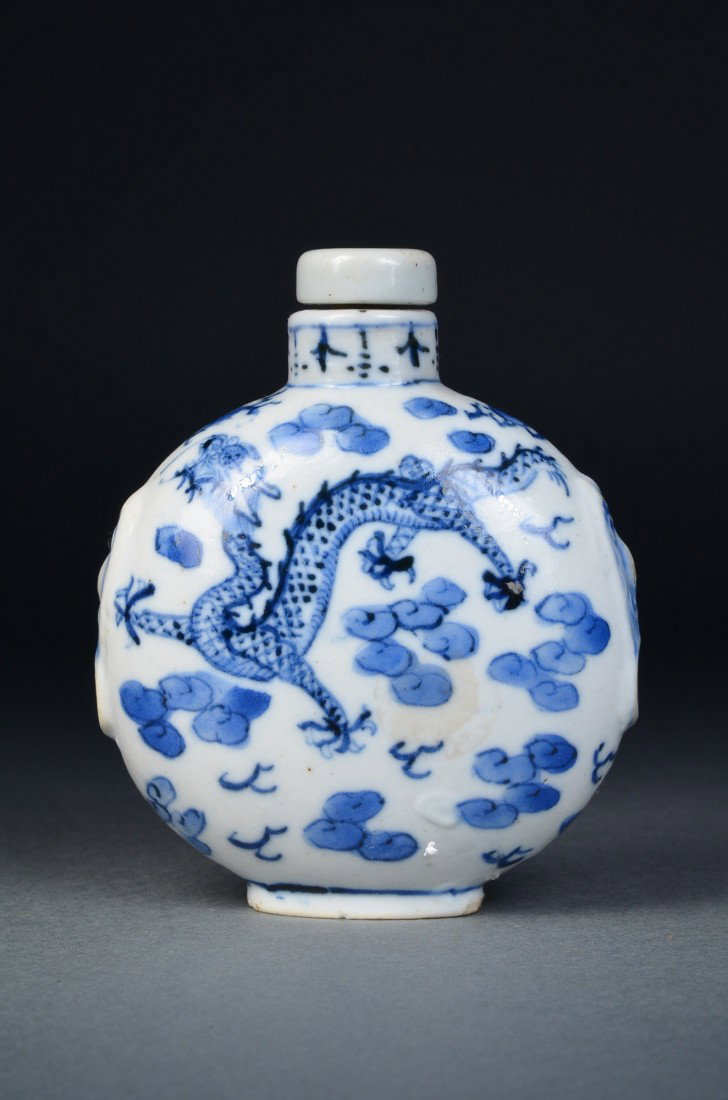 Chinese Blue & White Snuff Bottle Qianlong: Chinese blue and white porcelain snuff bottle; flattened body featuring five-toed dragon amid stylize ruyi-head cloud scrolls, matching stopper; four-character Qianlong Mark on base; H: 10 cm, L: 8.5 