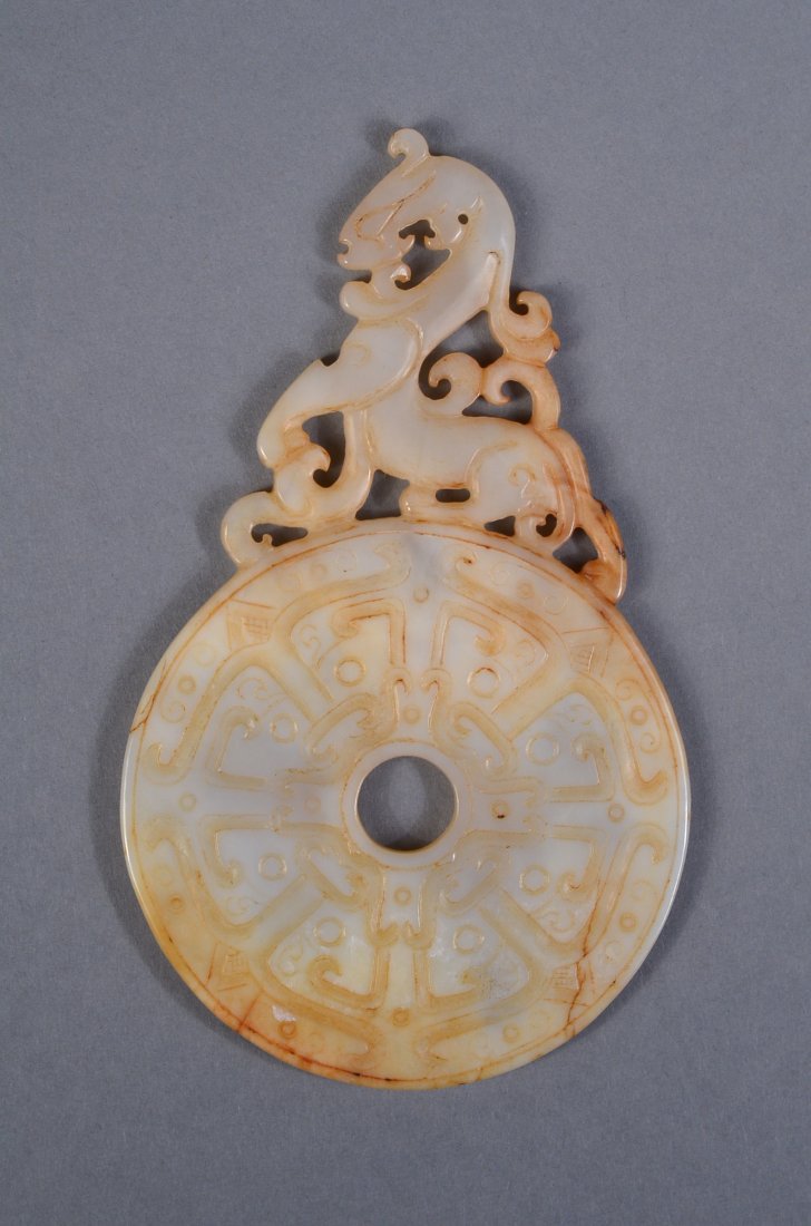 Chinese White Jade Dragon Bi Disc: Chinese carved white jade ritual bi disc; surmounted by chilong; the stone of translucent white tone with brown suffusions; H: 12 cm, D: 7 cm, 63 grams