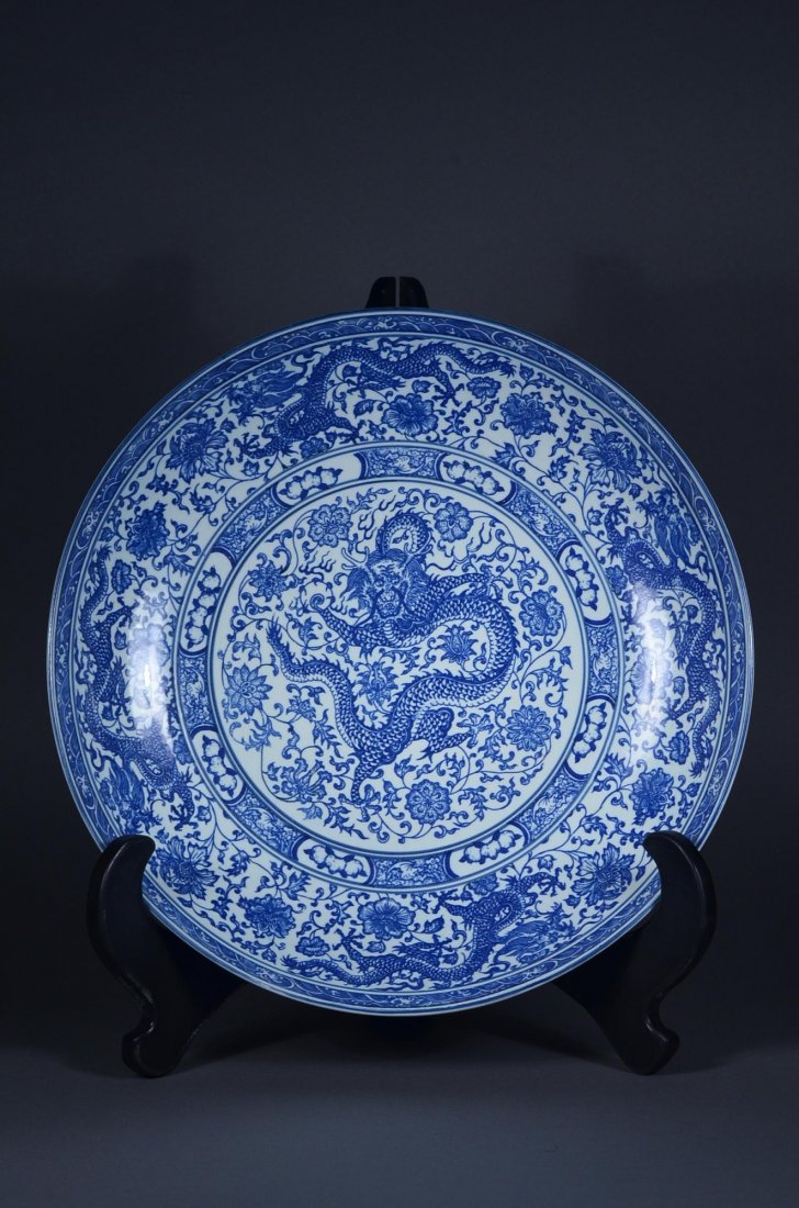 Chinese Blue & White Dragon Charger Qianlong: Chinese blue and white porcelain charger; with central medallion featuring five-toed dragon amid lotus spray, enclosed within band featuring bats; the cavetto decorated with lotus spray borne on undul