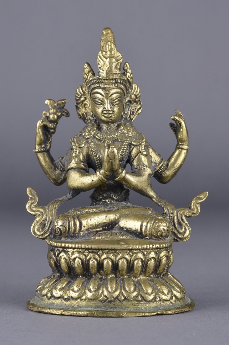 20th Century Chinese Bronze Avalokitesvara: 20th Century Chinese bronze figure of Avalokitesvara; featured with two hands grasping Buddhist ritual objects; the other two hands in mudra; seated in vajrasana atop double lotus pedestal; H: 12.5 cm