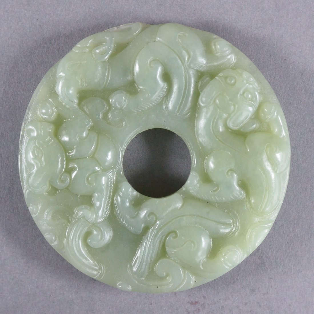 Vintage Chinese Carved Celadon Jade Bi Disc: Vintage Chinese carved jade bi disc; featuring chilong in relief on both sides; the stone of translucent celadon tone; D: 6 cm, 45 grams. Provenance: Chan Collection Toronto