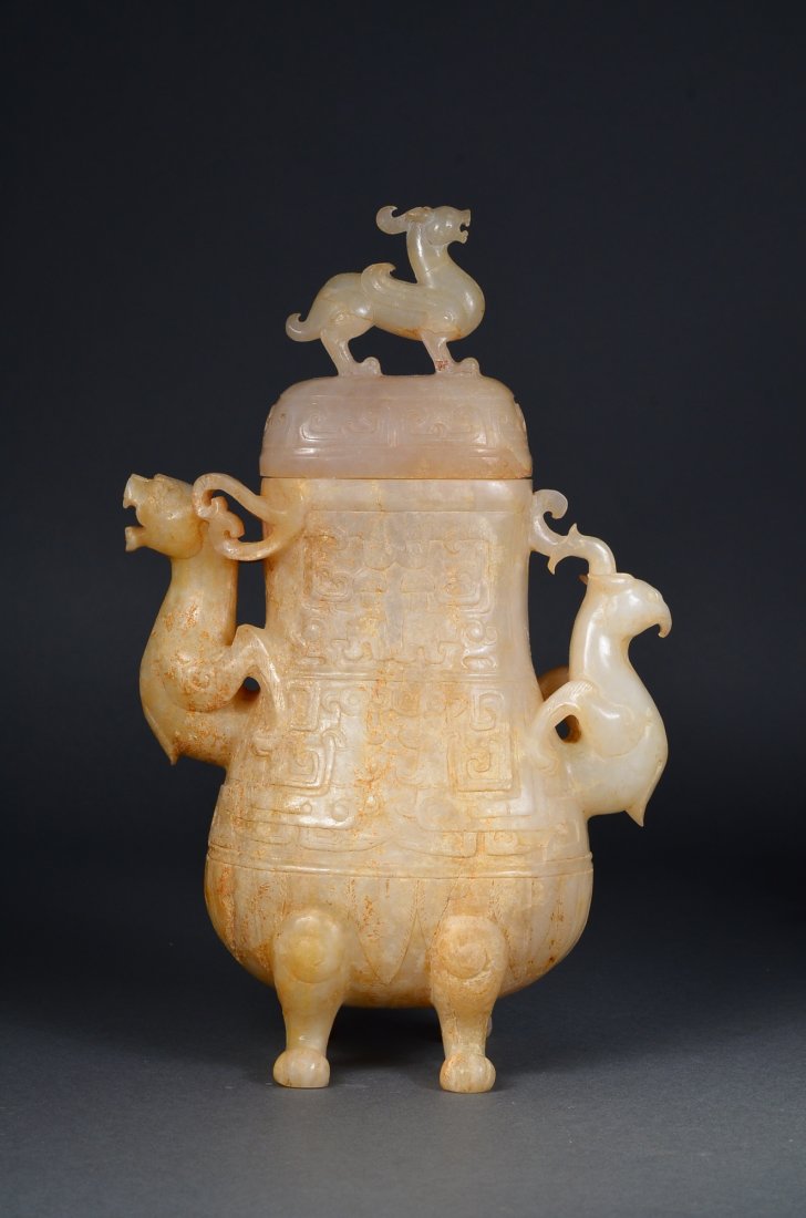 Chinese Ming Imperial White Hetian Jade Vase: Archaistic Chinese Ming Period carved imperial white Hetian jade vase; hu-shaped with taotie-like masks on body with handles in form of mythical beasts in openwork; domed cover surmounted by Qilin fin