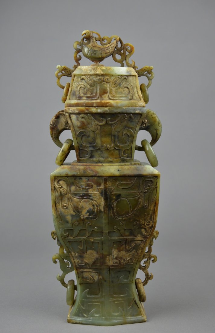 Chinese Han Dynasty Carved Green Jade Hu Vase: Well carved Han Dynasty Chinese jade hu vase; the middle featuring taotie-like masks in relief; the neck featuring elephant head handles suspending loose rings; the lower half featuring chilong flange