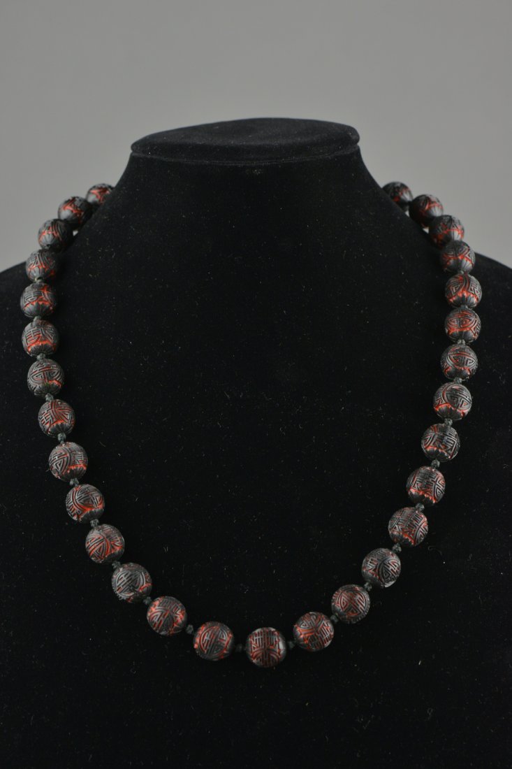 Chinese Cinnabar Lacquer Carved Shou Bead Necklace: Chinese cinnabar lacquer carved bead necklace featuring shou symbol in relief; L: 33 cm, 57 grams