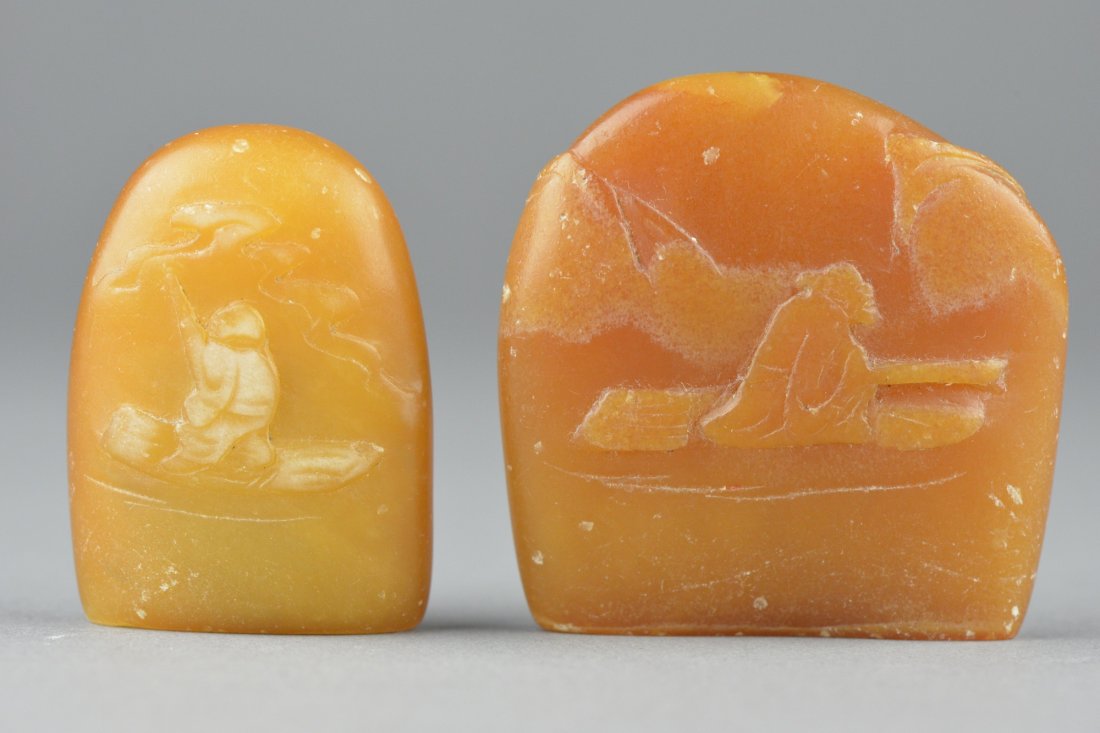 Set of Two Chinese Carved Shoushan Stone Boulders: Set of two Chinese carved shoushan stone boulders; both featuring landscape scene with sage in relief; the stone of light honey tone; L: 5 cm, 86 grams (larger) L: 5 cm, 55 grams (smaller)