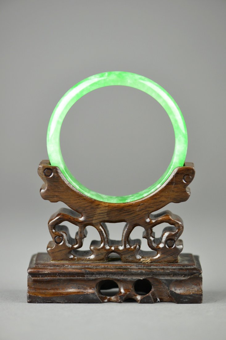 Set of Two Chinese Carved Jade & Agate Bangles: Two Chinese carved jadeite and agate bangles; the stones of translucent emerald green tone and turquoise tones; D: 7 cm, D: 6 cm (interior diameters), 48 grams. Stand not included