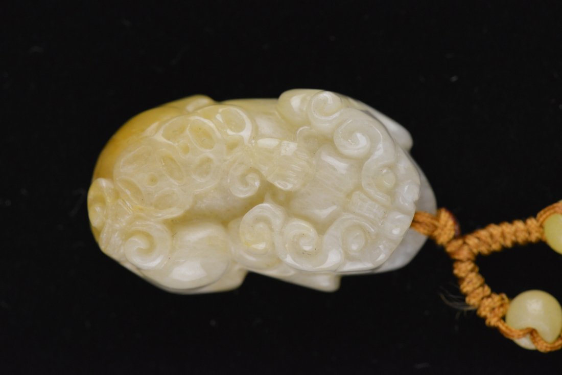 Fine Chinese Carved White Jade Pendant of Lion: Fine Chinese carved jade pendant; in form of lion in recumbent pose; the stone of translucent white tone with mutton fat suffusions; pierced for suspension; L: 3 cm, 16 grams