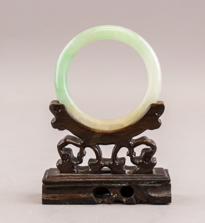 Chinese Green and Yellow Jadeite Carved Bangle: Chinese jadeite bangle of pale green and yellow. Carved into rounded inside and outside. Wood stand not included. Diam: 6cm (inner), 7.5cm (outer), Density: 3.25, 45.73g.