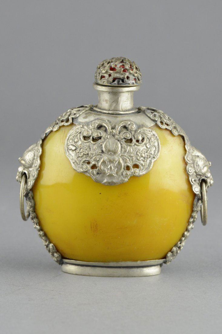Yellow Snuff Bottle with Silver Frame and Handles: Yellow snuff bottle with silver frame and handles; of circular form; frame carved bats, dragons and flower sprays; H: 11 cm, W: 10 cm, 258 grams