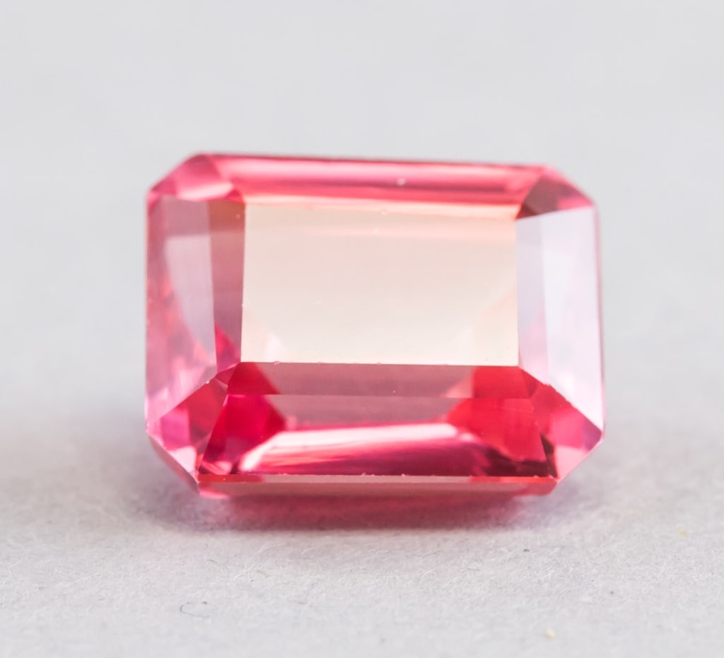 16.40ct Emerald Cut Pinkish Sapphire w/ GGL: 16.40ct emerald cut pinkish natural Padparadscha Sapphire. Accompanied with GGL certificate. 14.45 x 11.69 x 8.44mm.