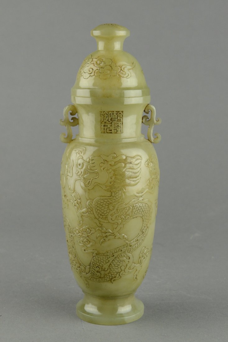 Chinese Carved Celadon Jade Vase with Lid Qianlong: A finely carved Chinese carved Jade vase of elongated ovoid form with dome lid. The jade vase is carved with a pair of writhing dragon on clouds. Neck flanked with vines as handles and carved Qianlong