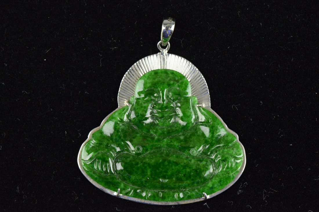 Green Jadeite Laughing Buddha w/ White Gold Mount: Of emerald green and near transparent stone, in form of a seating laughing Buddha mounted on white gold mount. H: 2.5 cm, W: 3.5 cm, 4 grams