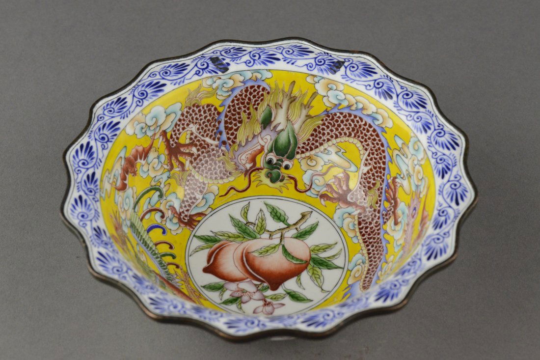 Chinese Bronze Canton Enameled Dragon Bowl: Bronze bell shape bowl with flaring rippled rims, the metal bowl is brightly painted with a pair of dragon and phoenix on yellow ground centered with a peach and framed with stylized vine scroll on th
