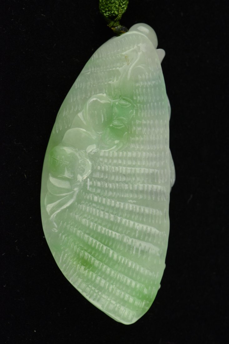 Chinese Jadeite Pendant Carved Clam & Bats: Of celadon tone with emerald green suffusions, the jadeite pendant is carved as a clam with bats and tong bao. H: 4 cm, W: 9 cm, 107 grams.