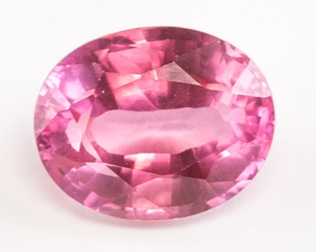 12.40ct Oval Cut Pinkish Natural Padparadscha GGL: 12.40 ct oval cut pinkish natural padparadscha sapphire. Accompanied with GGL certificate. 14.57 x 11.48 x 7.46 mm. Country of Origin: Sri Lanka *Information on Tariffs on Art and Antiques: Original A