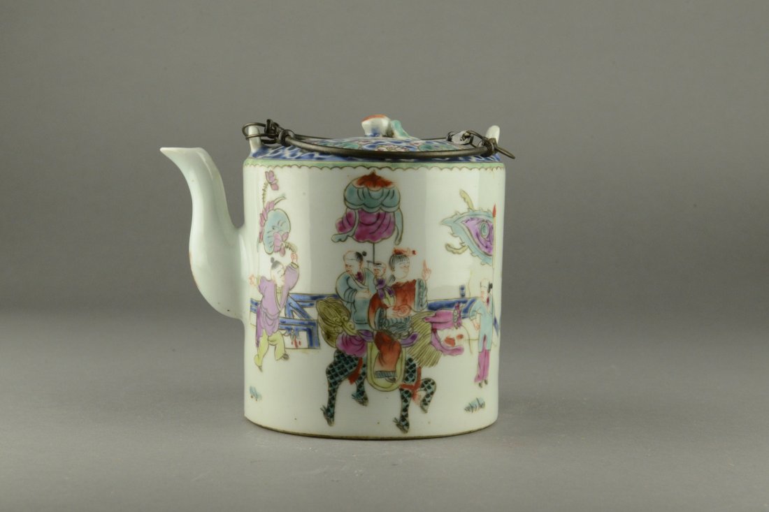 Chinese Porcelain Teapot with Guangxu Mark: The cylindrical teapot brightly painted with children at play with peonies sprays on the top side. With bronze handles. Top with two chips. Four character Guangxu mark on base. H: 14 cm, D: 13 cm, L: 
