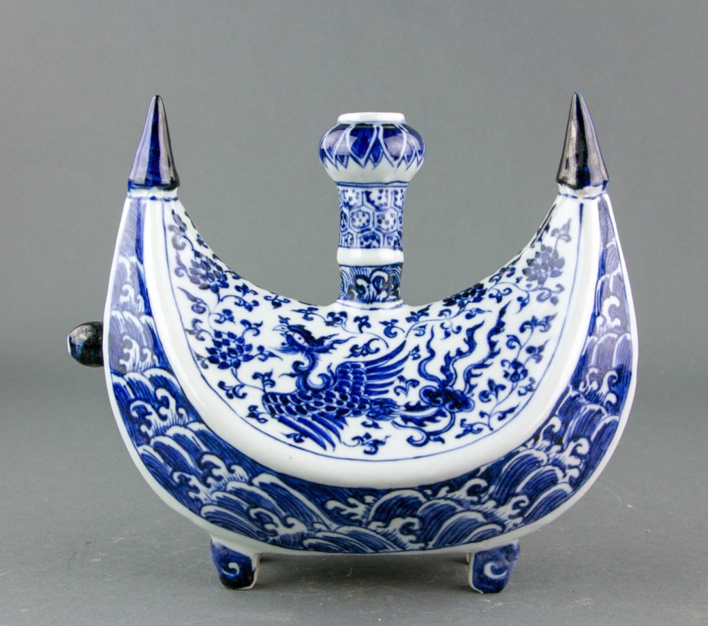 Chinese Blue & White Porcelain Flask Ewer Yongle: Chinese blue and white porcelain pilgrim flask ewer. Crescent-shaped body with a central cylindrical ringed neck with bulbous mouth; supported on four ruyi-shaped feet; decorated with phoenix amidst f