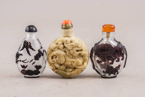 Chinese Peking Glass & Jade Snuff Bottles 3pc: Lot of 3 Chinese snuff bottles, including one carved jade bottle with dragon motifs and a red stopper, measuring approximately 3 inches in height. Accompanied by two Peking glass bottles: one with bla