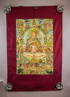 Tibetan Embroidery on Silk Padmasambhava Tangka: Embroidery on Silk. Featuring a central depiction of Padmasambhava seated on a lotus throne, surrounded by intricate floral patterns, deities, and attendants. The embroidery showcases vibrant colors a