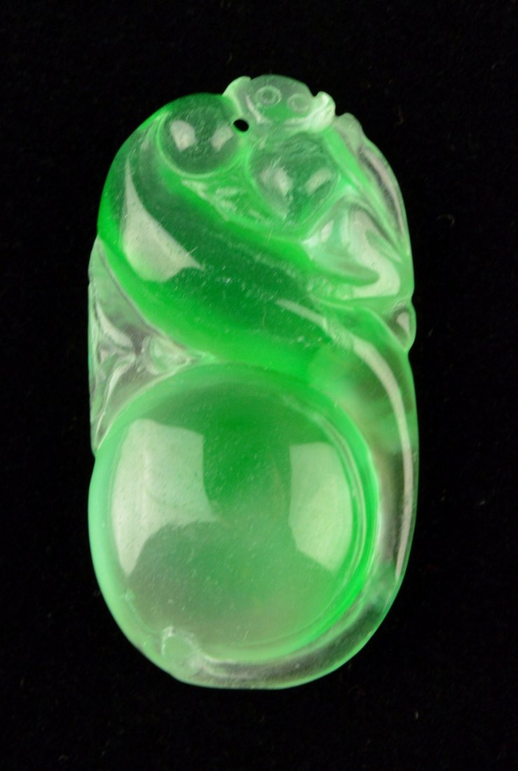 Exquisite Icy Emerald Green Jadeite Monkey Pendant: Exquisite icy jadeite carved pendant, featuring Fu monkey resting onto a vine with fruit hanging down. The stone of translucent emerald green tone with a curious glow of yellow. H: 4.2 cm, 17 grams.