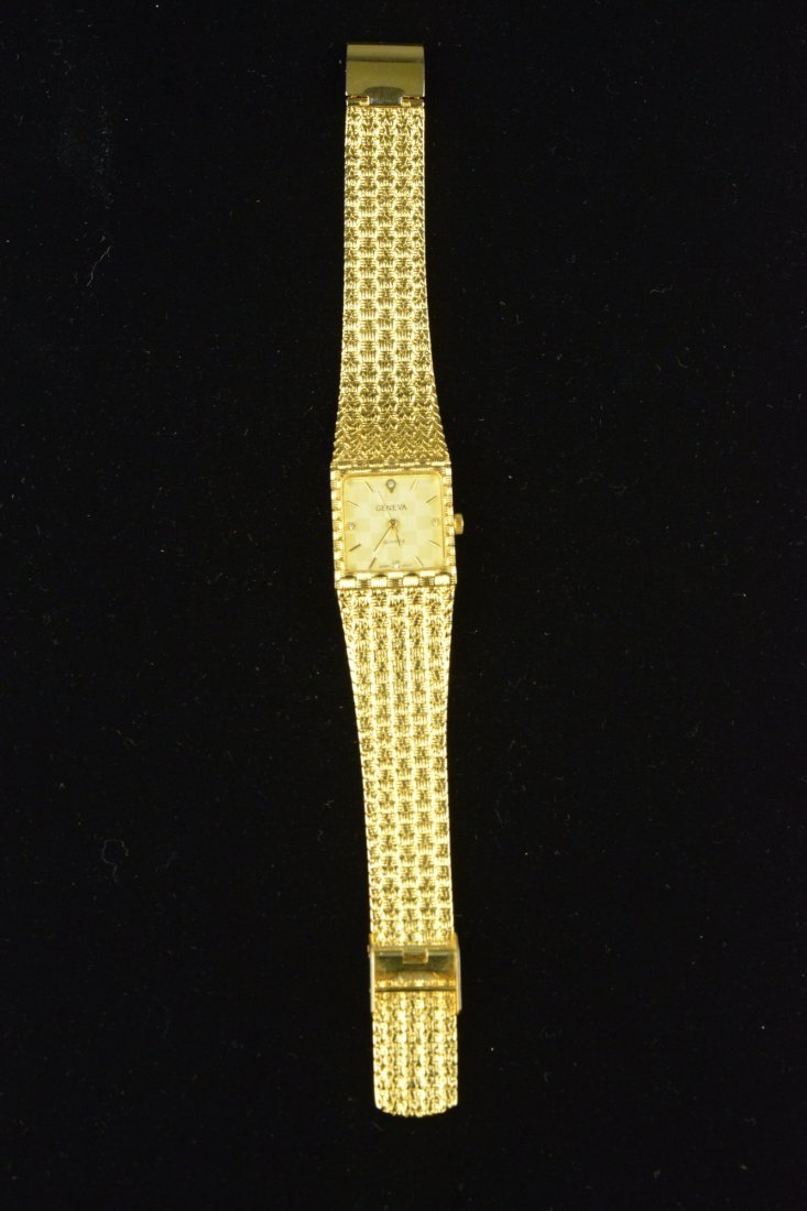Geneva 18K Yellow Gold Watch with Clear Stones: Geneva 18K yellow gold watch with clear stones possibly diamond. Stainless steel back. L: 22 cm, 61 grams.