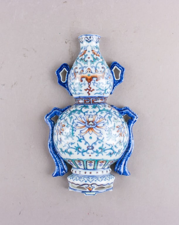 Chinese Doucai Porcelain Wall Vase w/ Qianlong MK: Chinese Doucai porcelain wall vase with Qianlong mark, featuring a double-gourd shape adorned with intricate floral and foliate motifs in vibrant blue, green, and orange enamels on a white ground. The
